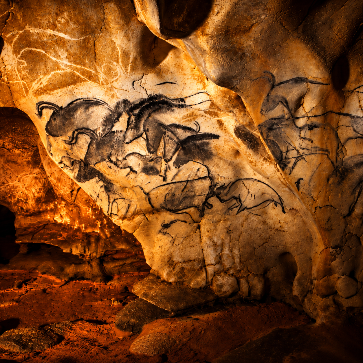 Amber-lit cave wall with drawings of horses, evoking prehistoric cave art